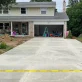 A newly poured concrete driveway leads up to a two story house